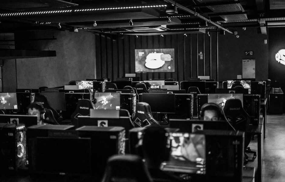 Black and white view of an active esports gaming studio with players immersed in video games.