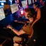 A group of gamers focused on a competitive match in a dimly lit esports arena.